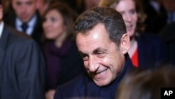 FILE - Former French President Nicolas Sarkozy leaves his headquarters in Paris, Nov. 29, 2014.