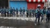 FILE - Bangladeshi policemen stand guard on a road near a court during a verdict against opposition leader and former Prime Minister Khaleda Zia in Dhaka, Bangladesh, Feb. 8, 2018.