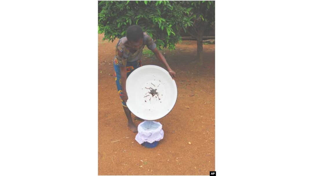 Aug. 17, 2005. Nigeria. A Nigerian adolescent demonstrates one technique used for filtering water to remove water fleas that carry Guinea worm larva. The Carter Center assists the Nigerian Ministry of Health in distributing water filters to protect people