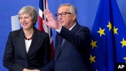 FILE - European Commission President Jean-Claude Juncker, right, greets British Prime Minister Theresa May at EU headquarters in Brussels, Nov. 21, 2018. 