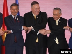 U.S. Secretary of State Mike Pompeo links hands with Singapore's Foreign Minister Vivian Balakrishnan and Thailand's Foreign Minister Don Pramudwinai at the East Asia Summit meeting in Bangkok, Aug.2, 2019.