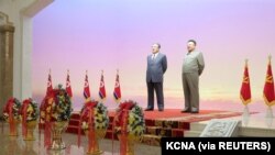 Patung Kim Il Sung dan Kim Jong Il. Pemimpin Korea Utara Kim Jong Un dan istrinya, Ri Sol Ju memberikan penghormatan kepada Kim Il Sung, untuk menandai ulang tahun pendiri negara bagian, di Pyongyang. (Foto: KCNA via Reuters)