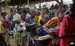 FILE - South Sudanese refugees line up for maize mash and beans at the Imvepi intake center near the Bidi Bidi refugee settlement in northern Uganda, June 6, 2017.