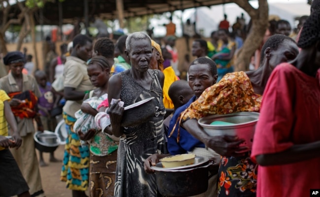 FILE - South Sudanese refugees queue to receive a meal, at the Imvepi intake center in northern Uganda, June 6, 2017.