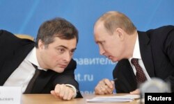 FILE - Russian Prime Minister Vladimir Putin, right, talks with Deputy Prime Minister Vladislav Surkov as they attend a meeting in Kurgan, Feb. 13, 2012.