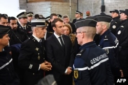 French President Emmanuel Macron (C) meets gendarmerie and police forces during his visit in the French northern city of Calais Jan. 16, 2018.