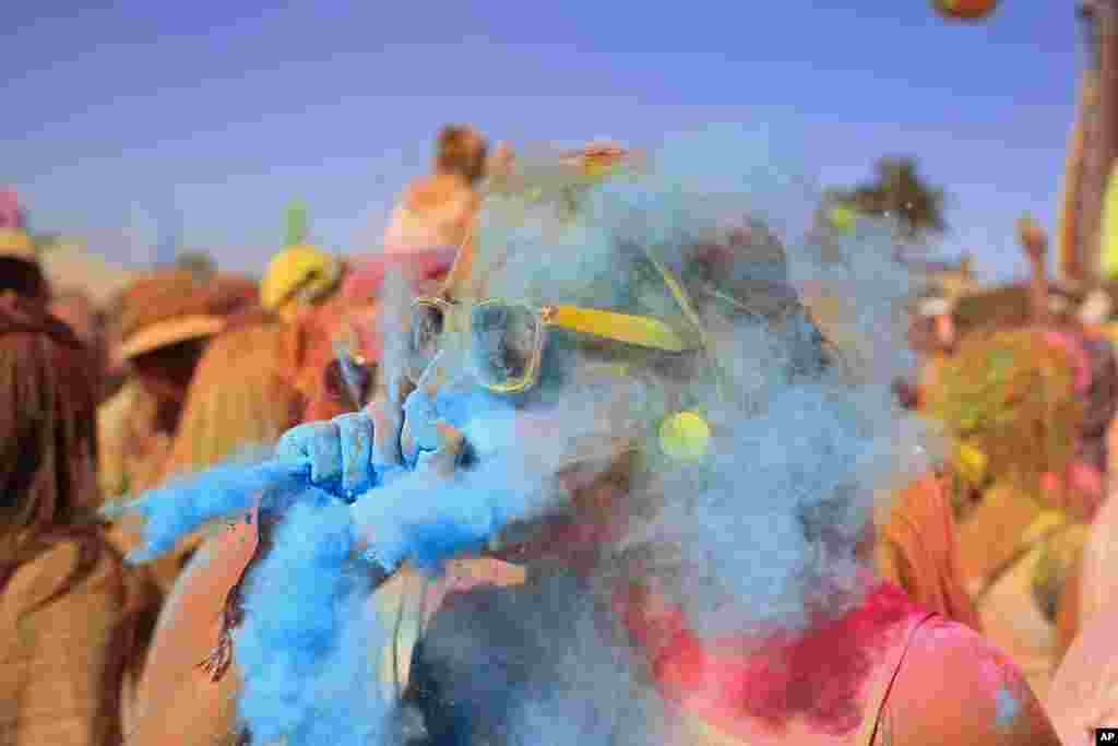 Một phụ nữ thổi bột sơn m&agrave;u xanh v&agrave;o người bạn trong Lễ hội m&agrave;u Holi One được tổ chức tại th&agrave;nh phố Cape Town, Nam Phi.