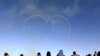 People watch as aircrafts perform during an airshow at Saudi Aviation Forum at Thumamah airport, in Riyadh, Saudi Arabia.