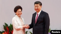 ທ່ານ​ນາງ Carrie Lam ຫົວໜ້າ​ບໍລິຫານ​ຮົງ​ກົງ​ ສຳພັດມືກັບ ປະທານປະເທດຈີນ ທ່ານ Xi Jinping. 