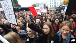 Polish women shout slogans while raising a hanger, the symbol of illegal abortion, during a nationwide strike and demonstration to protest a legislative proposal for a total ban on abortion in Warsaw, Poland, Oct. 3, 2016.