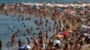 People sunbathe on a beach in Barcelona, Spain, Aug. 1, 2018. 