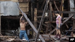 A man salvages a wood to repair his shanty destroyed during the height of typhoon Nesat as rains pour due to Typhoon Nalgae in Navotas town, north of Manila, Philippines, October 1, 2011.