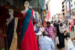 Seorang perempuan Sri Lanka mengenakan burka (berbaju hitam, kanan) di Kolombo, 13 Maret 2021. (AP Photo/Eranga Jayawardena)