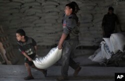 Palestinians receive food aid at a UN warehouse in the Shati refugee camp, Gaza City, Jan. 14, 2018.