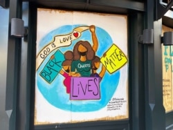 One of the protest murals designed by volunteers and mural artists of the P.A.I.N.T.S Institute adorns the plywood that boards exterior windows of a business, following the death of George Floyd in Minneapolis police custody, in downtown Washington, DC.