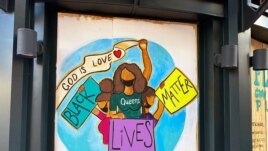 One of the protest murals designed by volunteers and mural artists of the P.A.I.N.T.S Institute adorns the plywood that boards exterior windows of a business, following the death of George Floyd in Minneapolis police custody, in downtown Washington, DC.