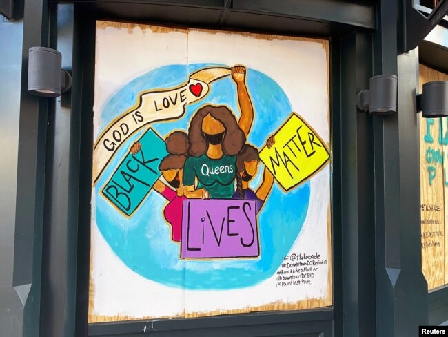 One of the protest murals designed by volunteers and mural artists of the P.A.I.N.T.S Institute adorns the plywood that boards exterior windows of a business, following the death of George Floyd in Minneapolis police custody, in downtown Washington, DC.