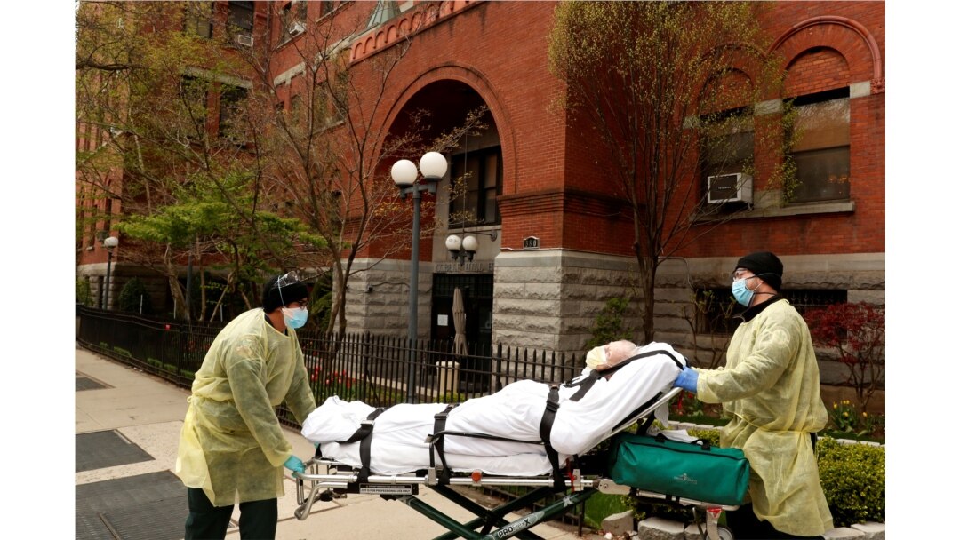 Los técnicos de emergencias médicas (EMT) sacan a un hombre del hogar de ancianos Cobble Hill Health Center durante un brote de coronavirus.