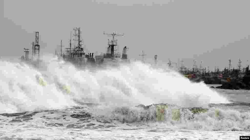 A big wave smashes into a breakwater at a fishing harbor in Jalaripeta in Visakhapatnam district in Andhra Pradesh, Oct. 11, 2013.
