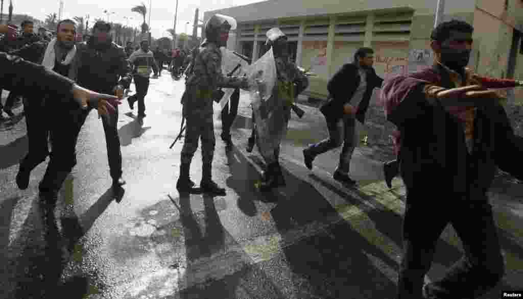 Egyptian Army soldiers (C) try to stop protesters opposing Egyptian President Mohamed Morsi from attacking the Security Directorate of Port Said, during a protest in Port Said Feb. 1, 2013.