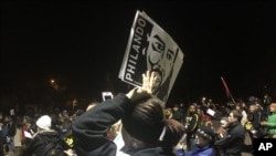 FILE - A woman holds a sign with Philando Castile's image during a rally in St. Paul, Minn., after a police officer was charged in Castile's fatal shooting in Falcon Heights, Nov. 16, 2016. The rally came after St. Anthony Police Officer Jeronimo Yanez was charged with second-degree manslaughter in the death of Castile, 32, a black man who was fatally shot July 6 in suburban St. Paul.