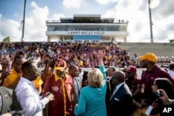 Democratic presidential candidate Hillary Clinton waves while visiting a homecoming game for Bethune-Cookman University Wildcats in Daytona Beach, Fla., Oct. 29, 2016, on her way to a rally.