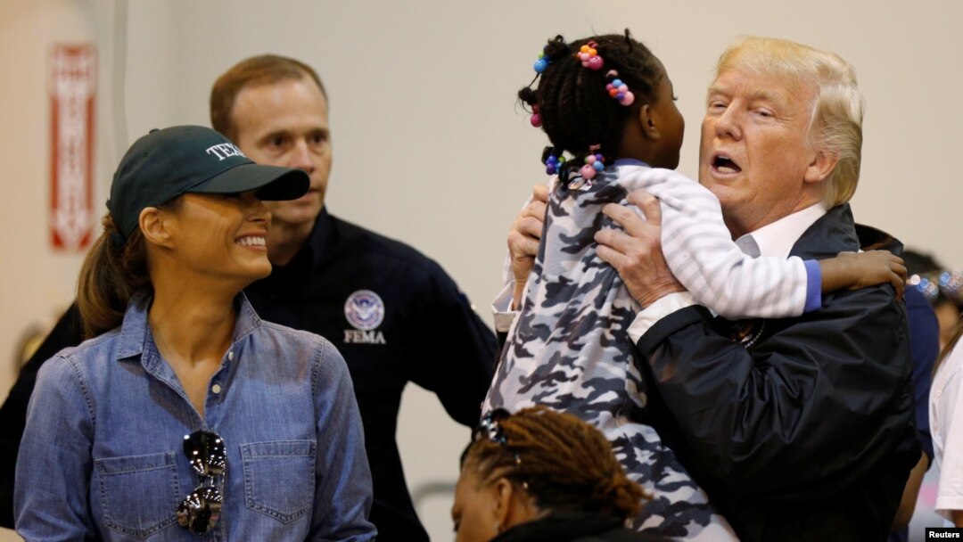 U.S. President Donald Trump lifts up a little girl as he and first lady Melania Trump visit with flood survivors of Hurricane Harvey at a relief center in Houston, Texas, Sept. 2, 2017.