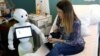 FILE - New recruit "Pepper" the robot, a humanoid robot designed to welcome and take care of visitors and patients, holds the hand of a new born baby next to his mother at AZ Damiaan hospital in Ostend, Belgium June 16, 2016. (REUTERS/Francois Lenoir)
