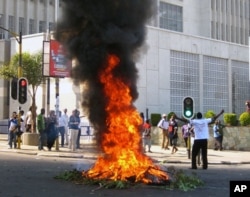 A protester burns vegetation in a street in Lilongwe, Malawi, Wednesday, July 20, 2011