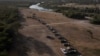 Vehículos militares y de las fuerzas del orden crean un cordón alrededor de los migrantes que se refugian en un campamento fronterizo improvisado cercano a lo largo del Puente Internacional en Del Rio, Texas, EE.UU. el 22 de septiembre de 2021. 