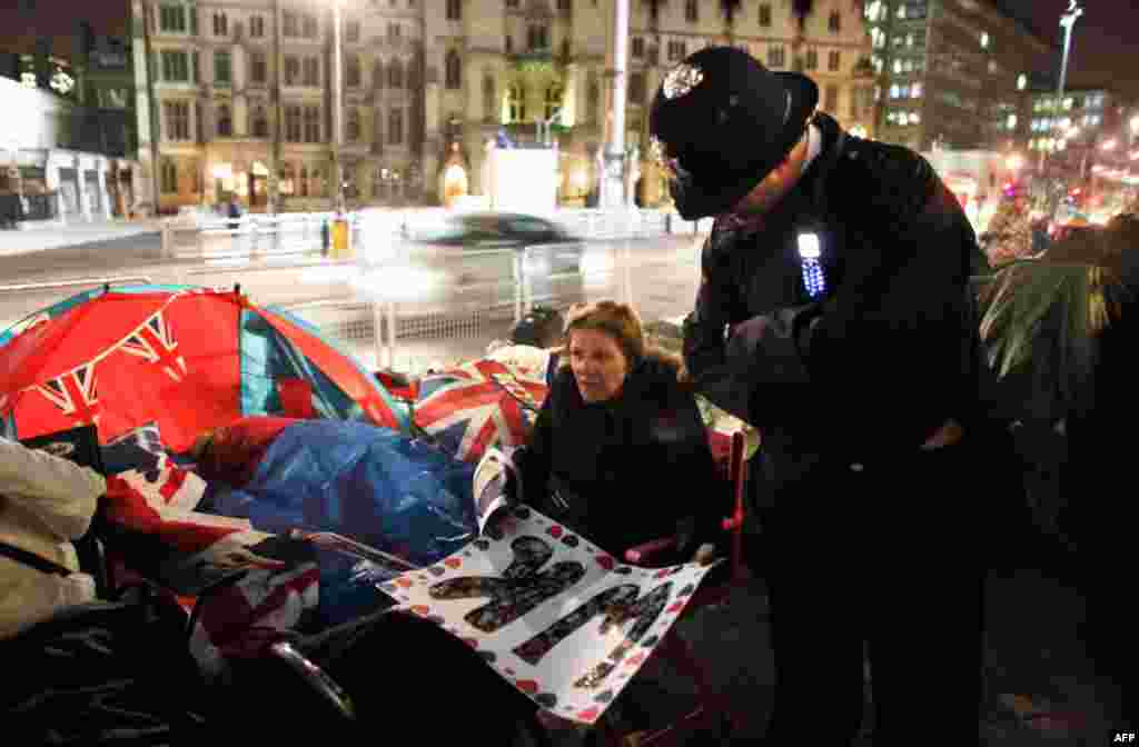 A policeman chats with a woman who spent the night opposite Westminster Abbey.(REUTERS/Nir Elias)