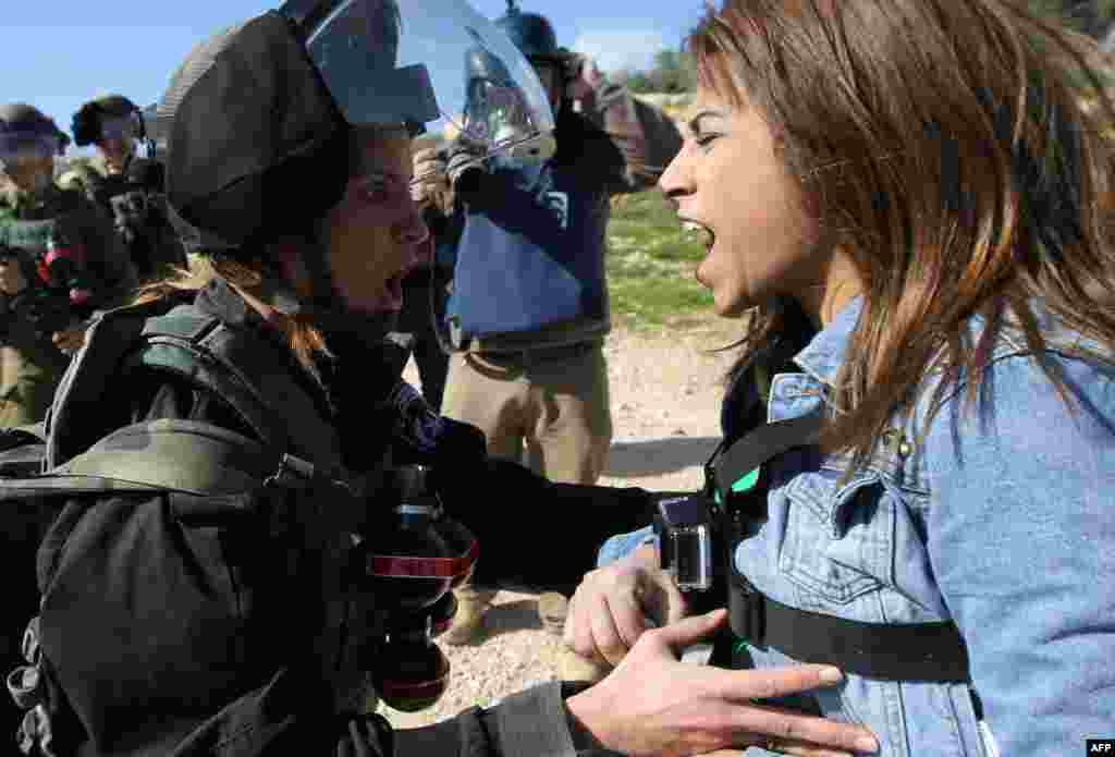 A Palestinian activist, Lema Nazeeh, argues with an Israeli soldier during clashes between security forces and Palestinians from the West Bank village of Bilin, following a march to protest against Israeli settlements, in Bilin, west of Ramallah. &nbsp;