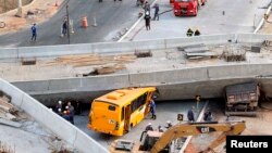 Petugas penyelamat mencoba mengeluarkan kendaraan-kendaraan yang terjebak di bawah jembatan penyeberangan yang ambruk saat sedang dibangun di Belo Horizonte, Brazil (3/7). 