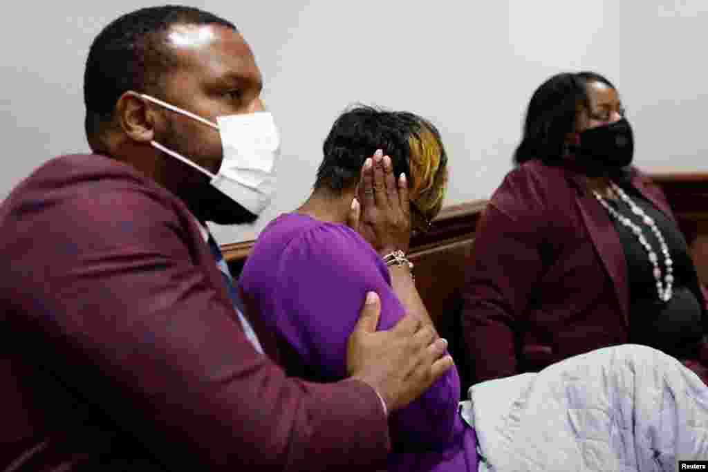 Attorney Lee Merritt comforts Wanda Cooper-Jones, mother of Ahmaud Arbery, as she reacts while seeing images of her son on a monitor, during the trial of William &quot;Roddie&quot; Bryan, Travis McMichael and Gregory McMichael, charged with the Feb. 2020 death of 25-year-old Ahmaud Arbery, at the Glynn County Courthouse in Brunswick, Georgia, Nov. 23, 2021.