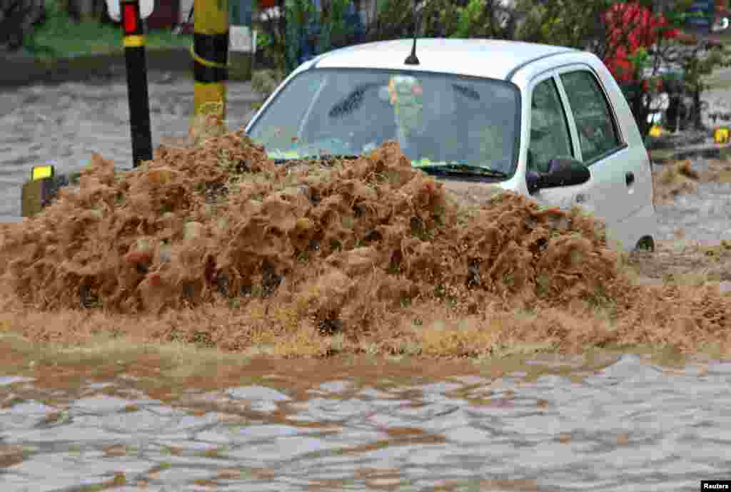 A car moves through a flooded road during heavy rains at Guwahati in the northeastern Indian state of Assam.