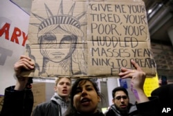 Demonstrators converge outside Terminal 5 of O'Hare International Airport, Jan. 29, 2017, in Chicago, as people protest President Donald Trump's executive order banning travel to the United States by citizens of several countries.