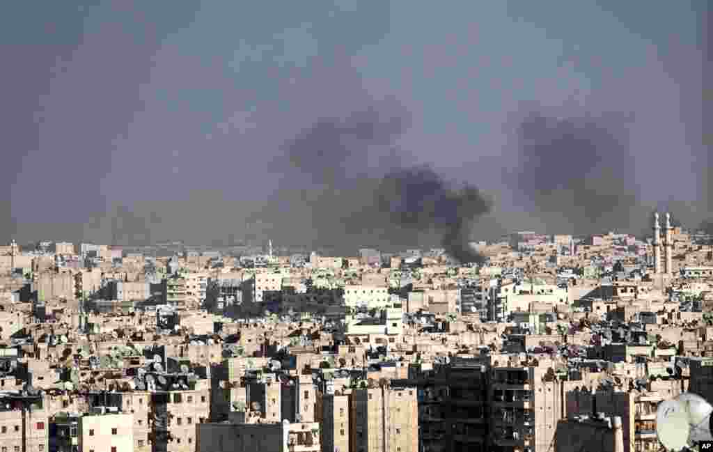 Smoke rises after a Syrian mortar shell landed in a neighborhood in Aleppo, November 14, 2012.