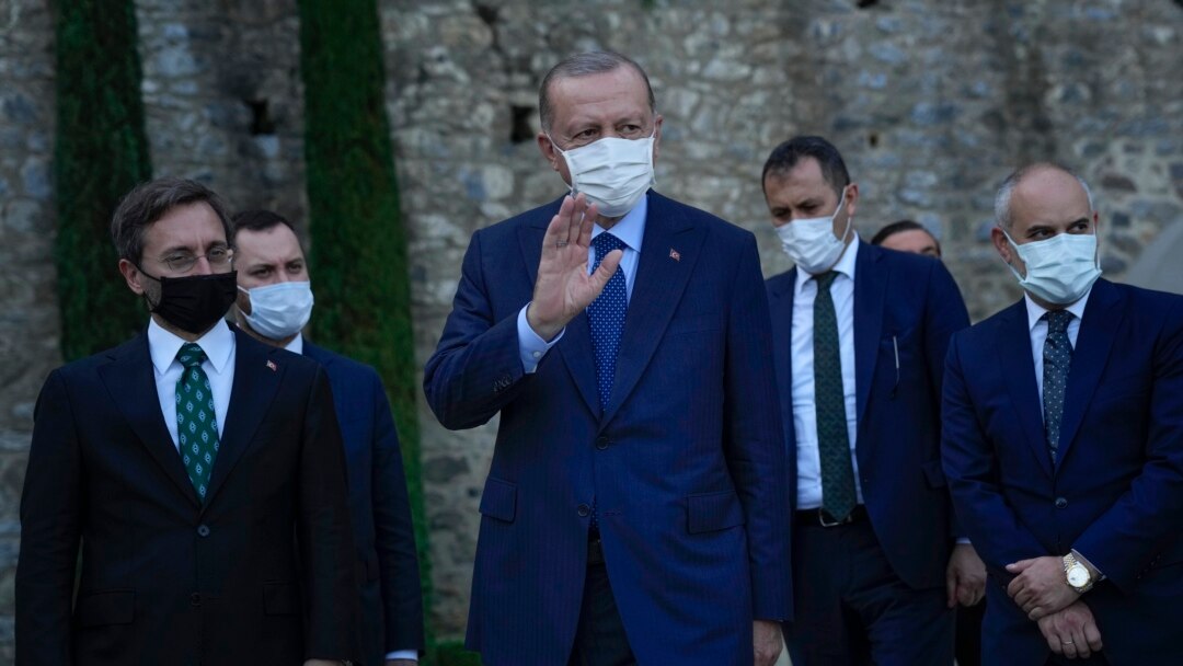 FILE - Turkey's President Recep Tayyip Erdogan, center, gestures to the media as he leaves after his meeting with German Chancellor Angela Merkel at Huber Villa presidential palace, in Istanbul, Turkey, Oct. 16, 2021.