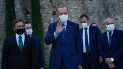 FILE - Turkey's President Recep Tayyip Erdogan, center, gestures to the media as he leaves after his meeting with German Chancellor Angela Merkel at Huber Villa presidential palace, in Istanbul, Turkey, Oct. 16, 2021.