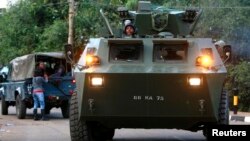 A armored military vehicle drives from the Westgate shopping center after an exchange of gunfire. Sept. 23, 2013. 