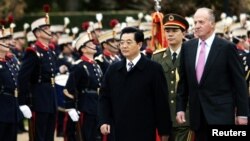 China's President Hu Jintao (L) and Spain's King Juan Carlos review the guard of honour during a traditional welcome ceremony at Madrid's Pardo Palace outside Madrid November 14, 2005. Hu arrived to Spain on Sunday for a two-day state visit. REUTERS/Susan