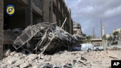 In this photo provided by the Syrian Civil Defense group known as the White Helmets, a destroyed ambulance is seen outside the Syrian Civil Defense main center after airstrikes in Ansari neighborhood in the rebel-held part of eastern Aleppo, Sept. 23, 2016.