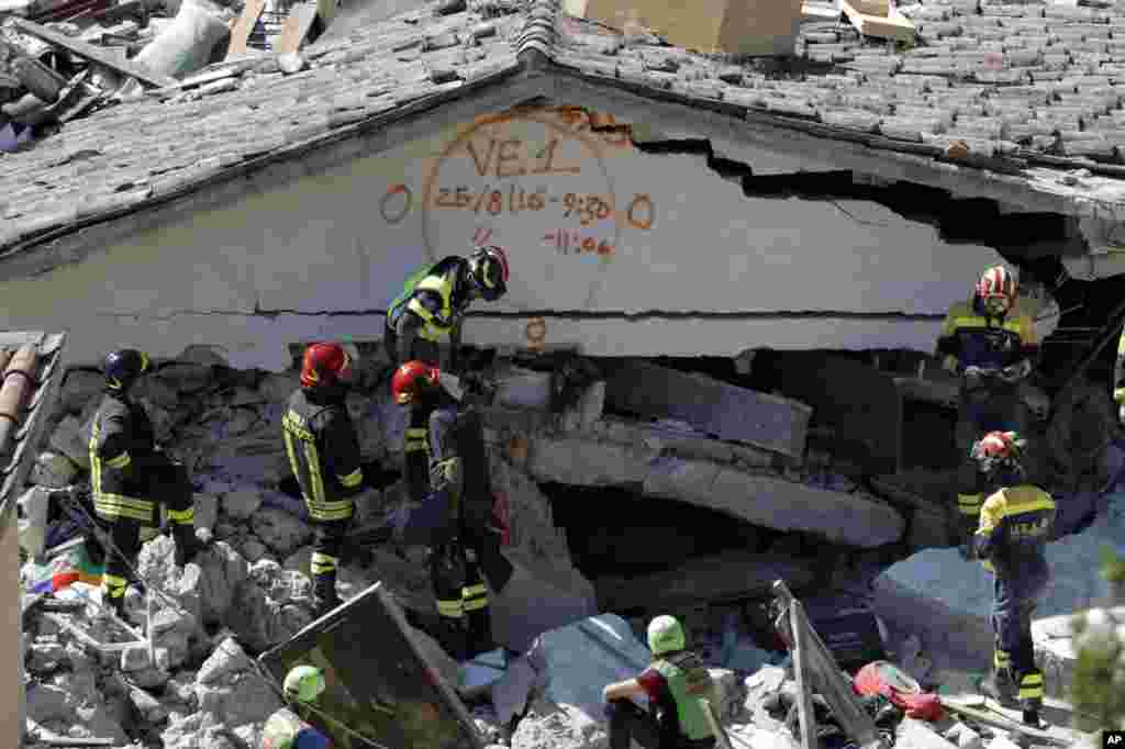 Rescuers mark a building with paint signaling the date and time of start and end of the search operation on that building, following Wednesday&#39;s earthquake in Pescara Del Tronto, Italy, Aug. 25, 2016.