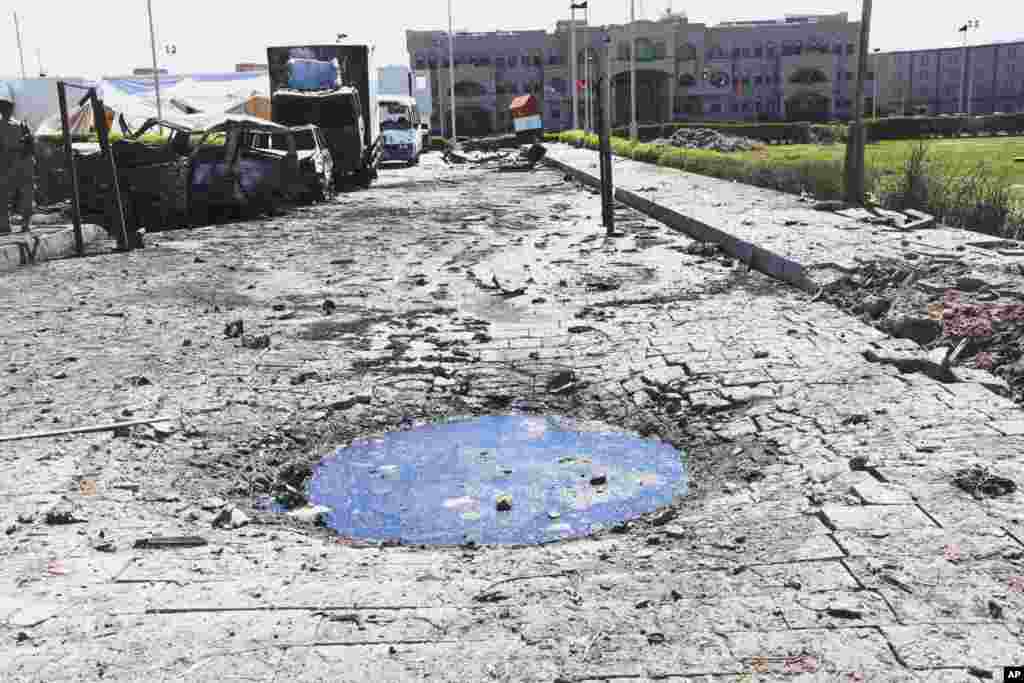 This photo provided by Yemen's Defense Ministry shows a crater and damaged vehicles after an explosion at the Defense Ministry complex in Sana'a, Dec. 5, 2013.