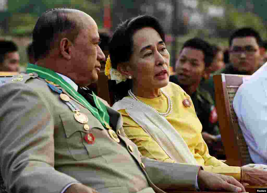 Burma's opposition leader Aung San Suu Kyi speaks with Deputy Minister for Border Affairs Major General Zaw Win during the 68th Armed Forces Day in Naypyitaw, March 27, 2013. 