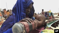 A mother quenches her malnourished child's thirst while waiting for food handouts at a health center in drought-stricken remote Somali region of Eastern Ethiopia.