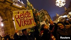 A man holds a placard during an anti-government protest called by civil groups in Budapest, Hungary, Jan. 2, 2015. 