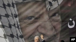 Palestinian president Mahmoud Abbas speaks during a rally marking the 6th anniversary of the death of his predecessor, Yasser Arafat, pictured in the background, in Ramallah, the West Bank, 11 Nov 2010