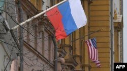 မော်စကိုမှာရှိတဲ့ အမေရိကန်သံရုံးဘေးက ရုရှားအလံကို မြင်ရစဉ်။ (ဧပြီ ၁၅၊ ၂၀၂၁)