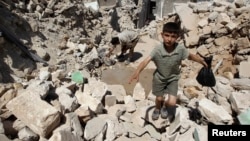 A boy walks on the rubble of buildings damaged by what activists said were missiles fired by Syrian Air Force fighter jets loyal to President Bashar al-Assad in Salqin city, Idlib governate, May 28, 2013.